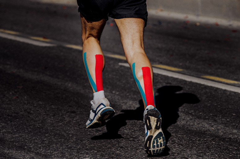 runner-with-kinesio-tape-on-legs-sports-injury-fix